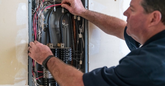 man looking at electrical panel